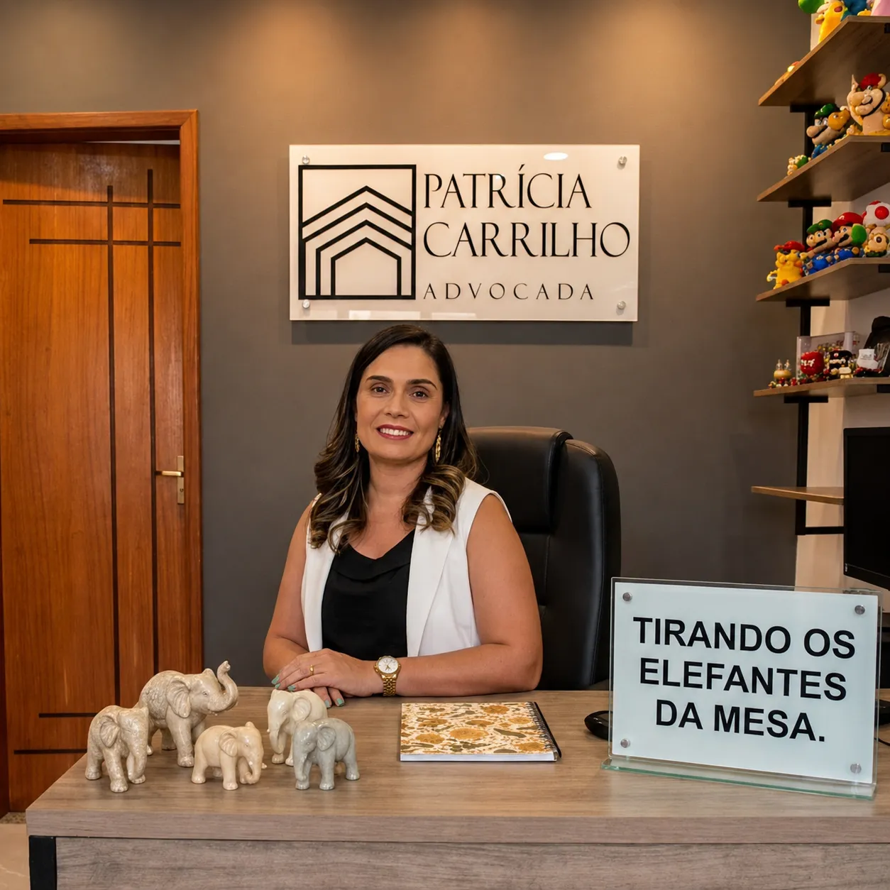 Patrícia Carrilho no escritório, com a placa Tirando os elefantes da mesa